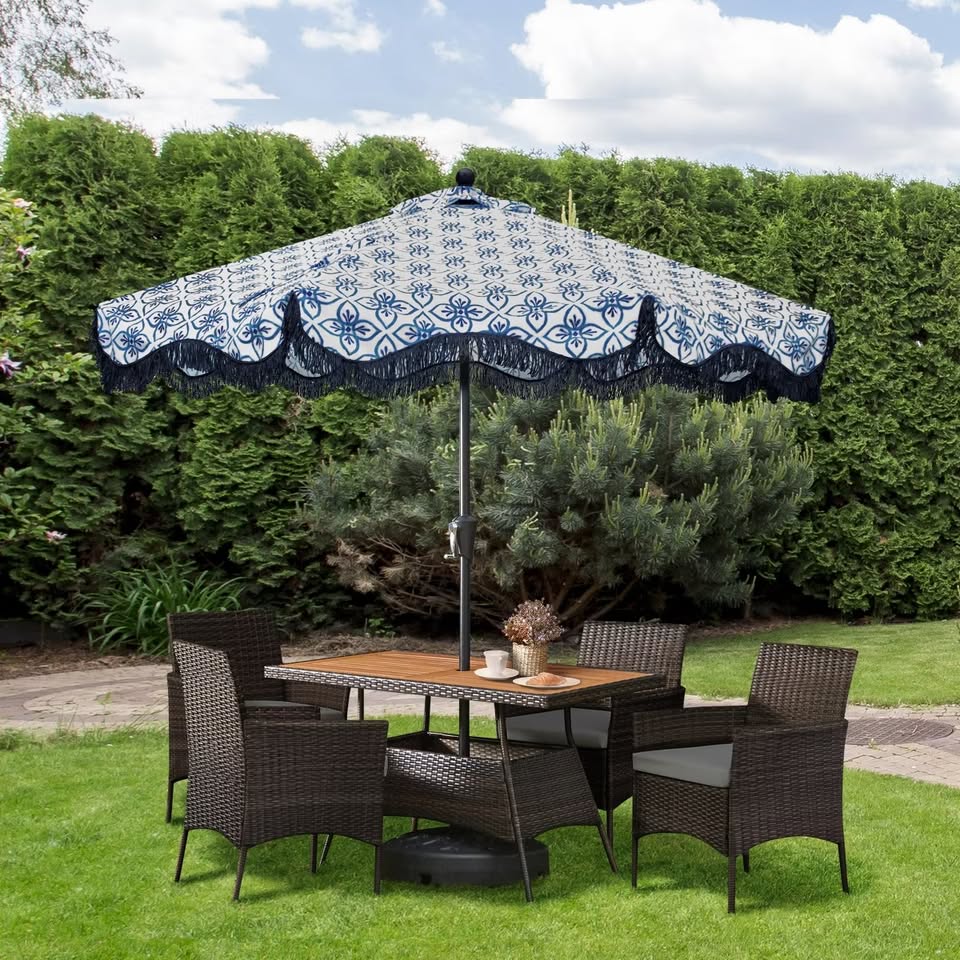 Wicker outdoor dining set with umbrella in backyard